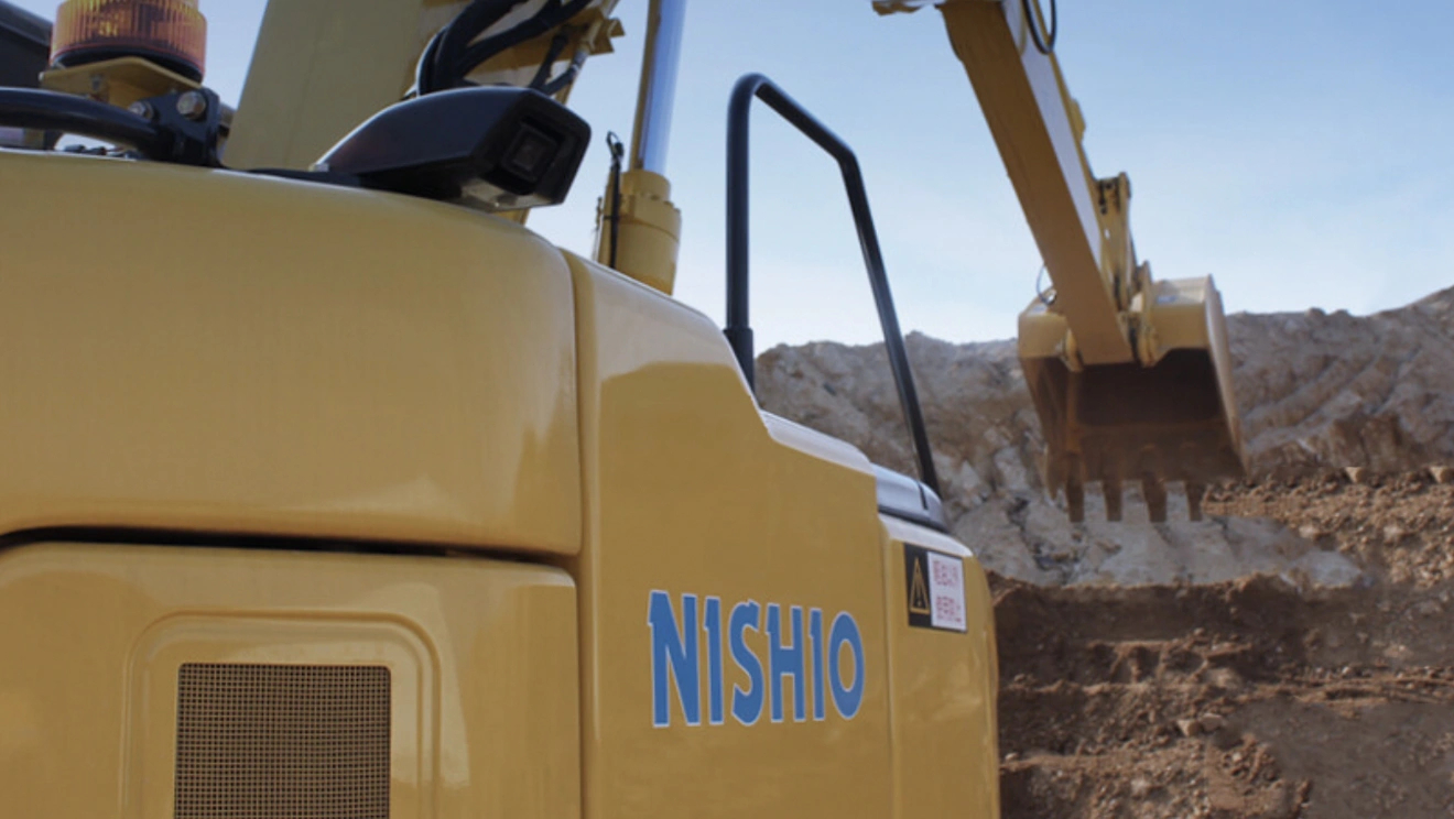 NISHIOロゴが入ったバックホウが稼働する建設現場の様子
